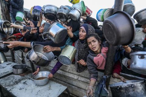 People gather to receive meals from the Rafah charitable kitchen (Tekka) as Palestinians face famine, in Khan Yunis, in the southern Gaza Strip, on January 2, 2025.
