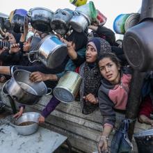 People gather to receive meals from the Rafah charitable kitchen (Tekka) as Palestinians face famine, in Khan Yunis, in the southern Gaza Strip, on January 2, 2025.