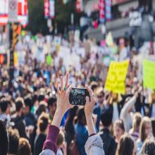 Protester takes a photo of the assembled crowd