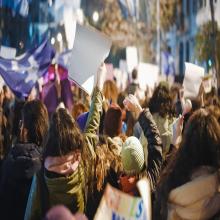 Assembled crowd of protesters holding up banners
