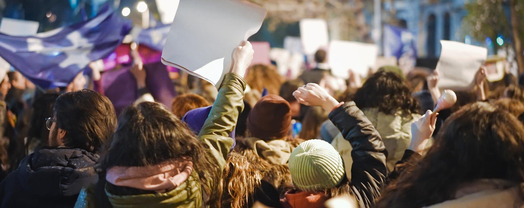Assembled crowd of protesters holding up banners